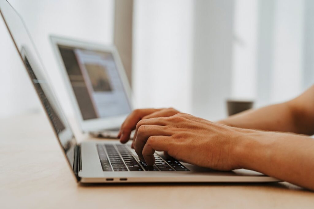 Focused view of hands typing on a laptop, symbolizing modern technology and connectivity.